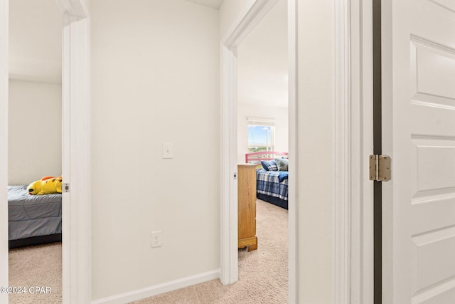 hall featuring light colored carpet