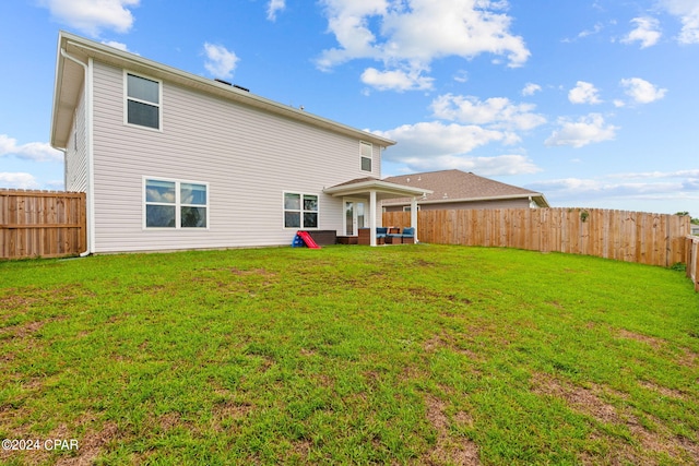 rear view of property with a lawn