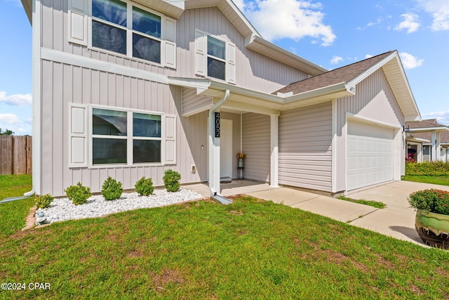 view of front of property featuring covered porch, a front yard, and a garage