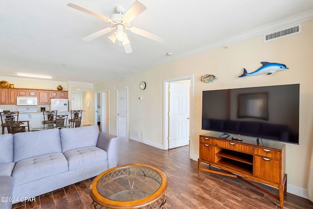 living room featuring ornamental molding, ceiling fan, dark hardwood / wood-style floors, and a textured ceiling