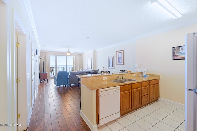 kitchen with crown molding, white appliances, and kitchen peninsula