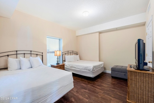 bedroom featuring a textured ceiling and dark hardwood / wood-style flooring