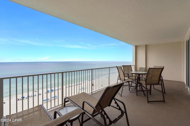 balcony featuring a beach view and a water view