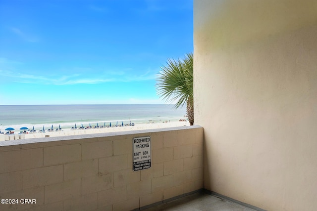 balcony featuring a view of the beach and a water view