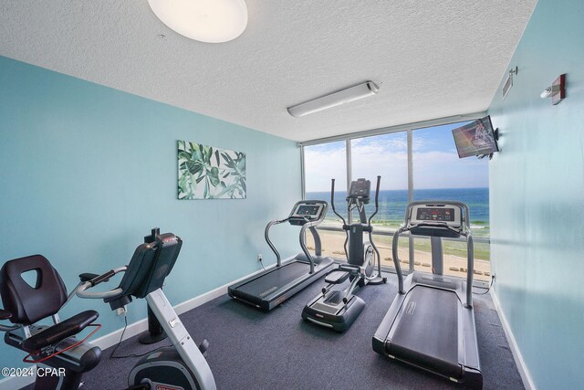 workout area with a textured ceiling and a wall of windows