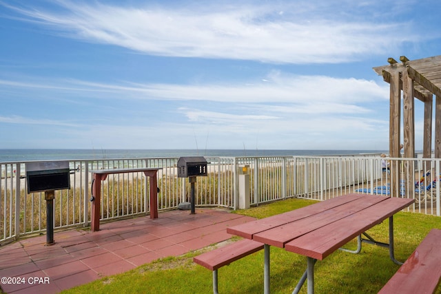 exterior space featuring a view of the beach, a pergola, and a water view