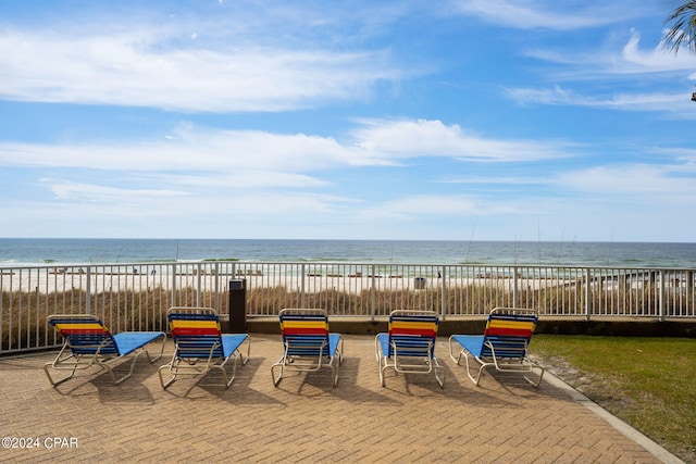 view of patio featuring a water view and a beach view