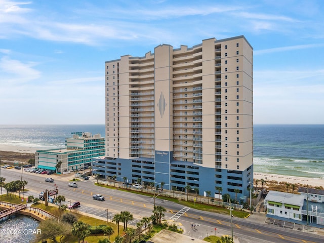 view of building exterior featuring a water view and a beach view