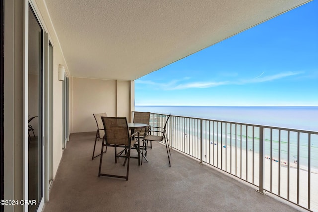 balcony featuring a water view and a beach view