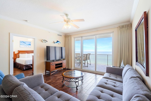 living room with a textured ceiling, crown molding, hardwood / wood-style floors, and ceiling fan