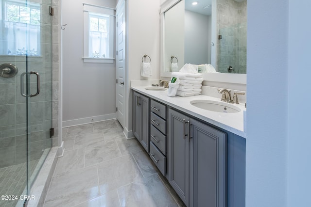 bathroom featuring a shower with shower door and vanity