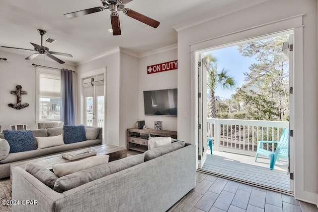 living room with ceiling fan, ornamental molding, and a healthy amount of sunlight