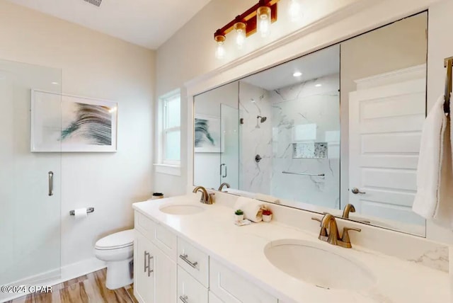 bathroom featuring vanity, hardwood / wood-style floors, an enclosed shower, and toilet