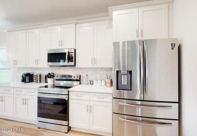 kitchen featuring white cabinets, appliances with stainless steel finishes, and light hardwood / wood-style floors