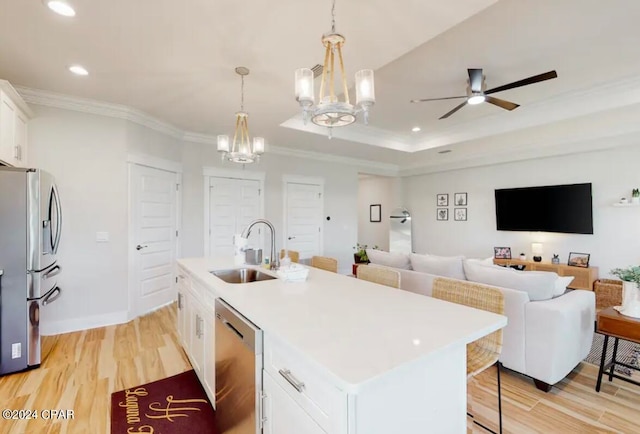 kitchen featuring white cabinets, a kitchen island with sink, appliances with stainless steel finishes, ceiling fan with notable chandelier, and light hardwood / wood-style floors