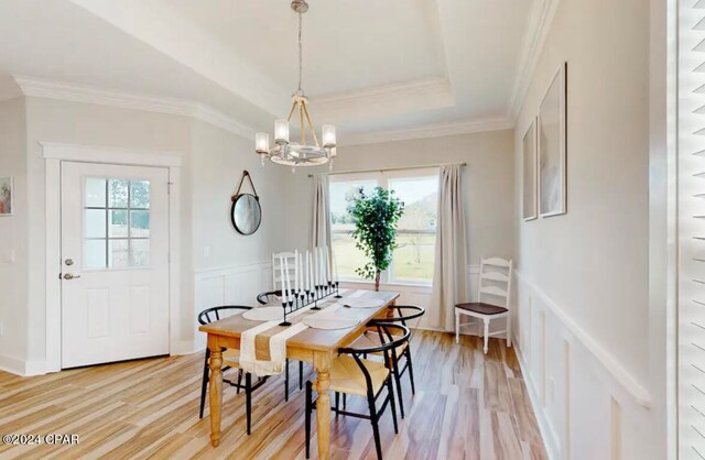 dining room with ornamental molding, hardwood / wood-style flooring, a chandelier, and a healthy amount of sunlight