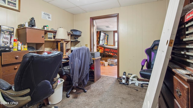 carpeted office space with a paneled ceiling