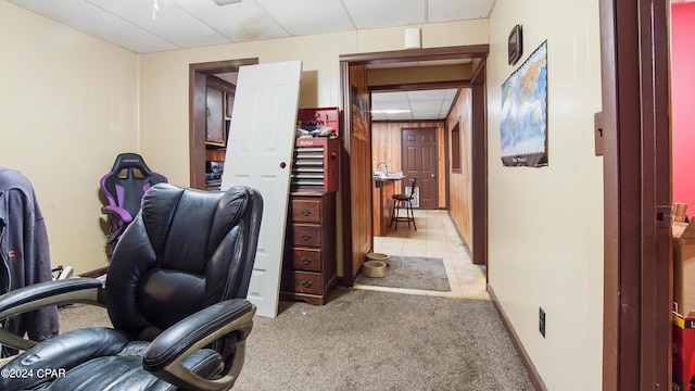 carpeted home office with wooden walls