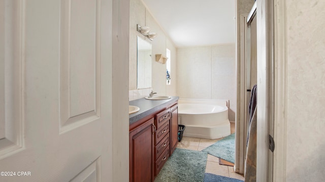 bathroom with tile patterned flooring, independent shower and bath, and vanity