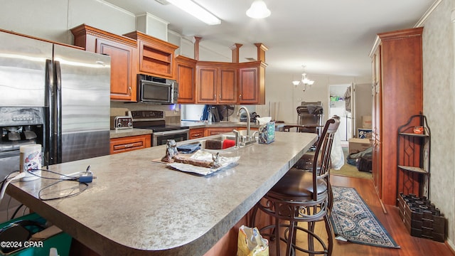 kitchen with an inviting chandelier, appliances with stainless steel finishes, sink, and dark hardwood / wood-style flooring