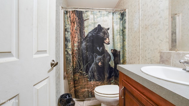 bathroom featuring walk in shower, vanity, and toilet