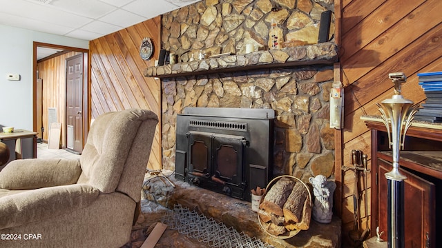 living room featuring a paneled ceiling and wood walls