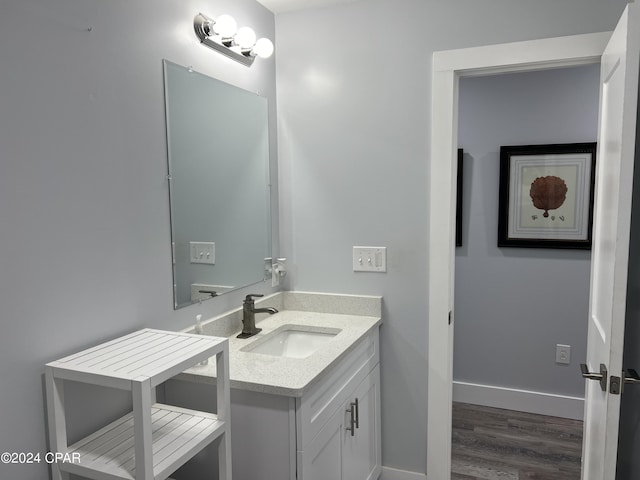 bathroom with vanity, baseboards, and wood finished floors