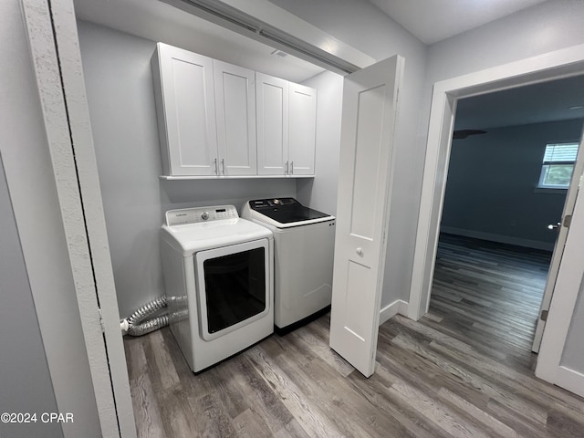 washroom with dark hardwood / wood-style flooring, independent washer and dryer, and cabinets