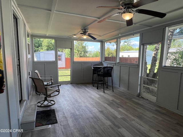 sunroom featuring ceiling fan and plenty of natural light