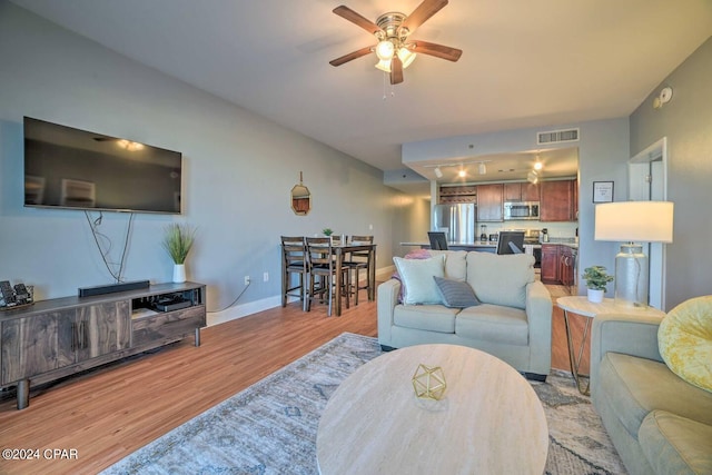 living room with light wood-type flooring and ceiling fan