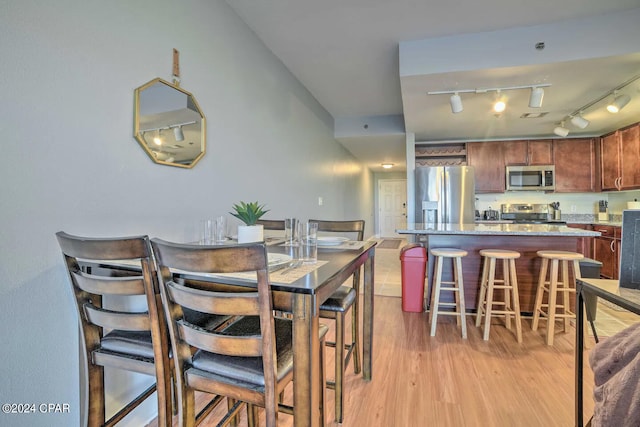 dining area featuring light hardwood / wood-style flooring and rail lighting