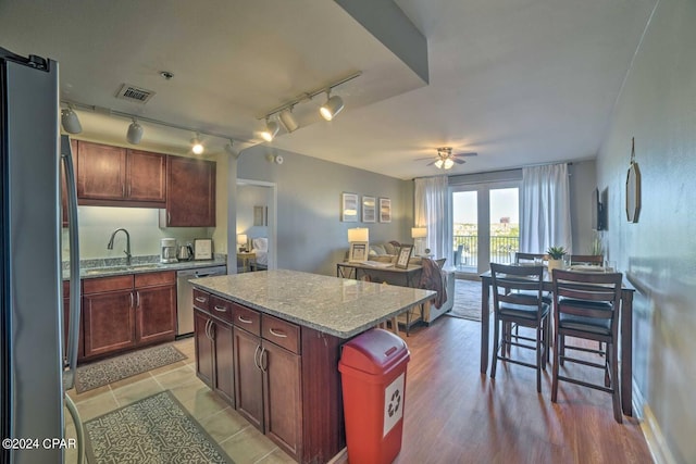 kitchen featuring ceiling fan, sink, a kitchen island, track lighting, and appliances with stainless steel finishes