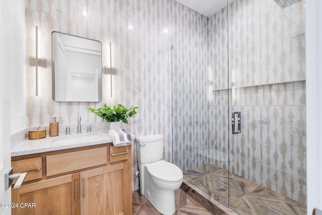 bathroom with tile walls, vanity, walk in shower, parquet floors, and toilet