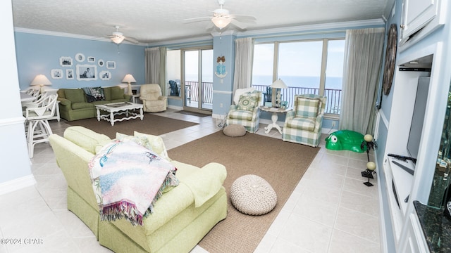 tiled living room with ceiling fan, crown molding, and a water view