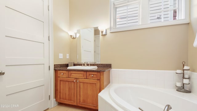 bathroom featuring tiled tub and vanity