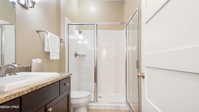 bathroom featuring tile patterned floors, a shower with shower door, vanity, and toilet