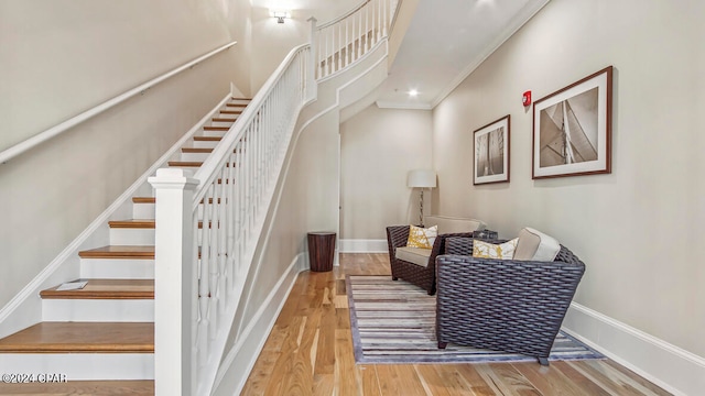 staircase featuring ornamental molding and wood-type flooring