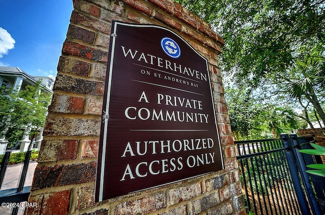 community / neighborhood sign with fence