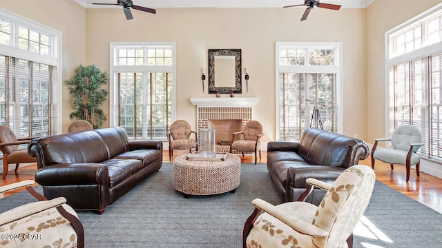 living room featuring a high ceiling, a fireplace, hardwood / wood-style floors, and ceiling fan