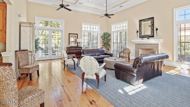 living room with a healthy amount of sunlight, a high ceiling, ceiling fan, and a brick fireplace