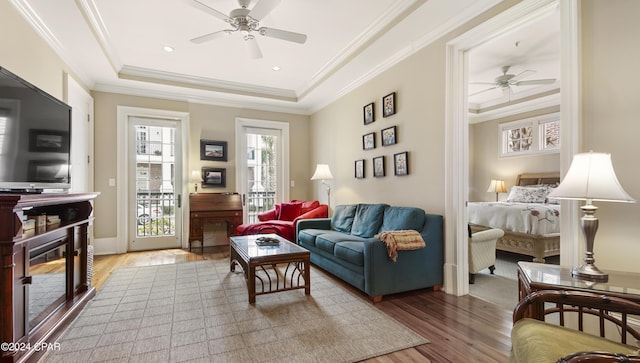 living room featuring crown molding, wood finished floors, and ceiling fan