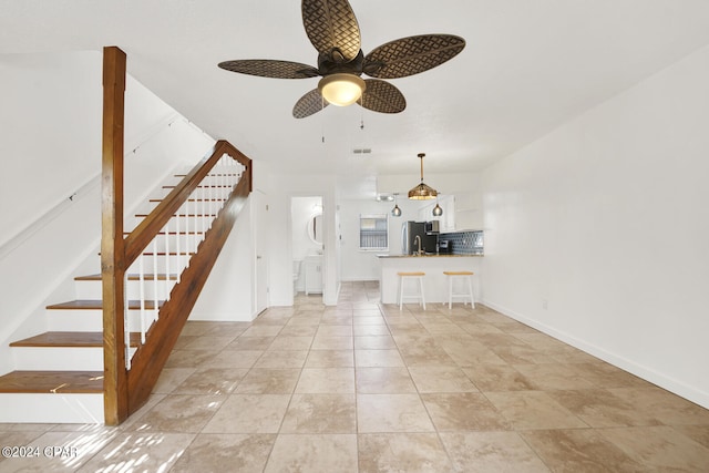 unfurnished living room with ceiling fan