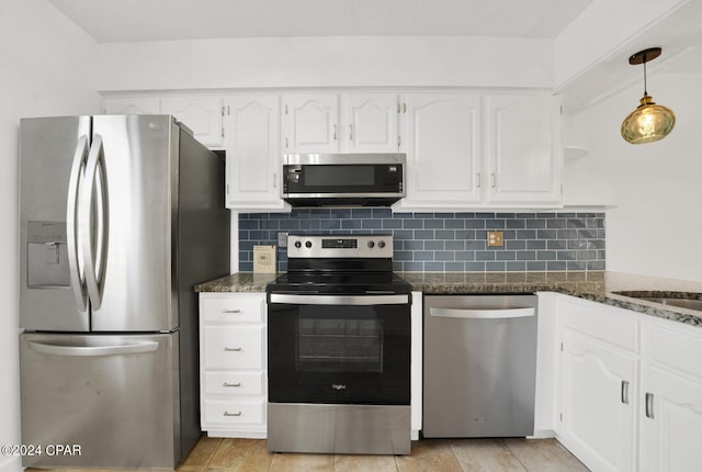 kitchen featuring white cabinets, appliances with stainless steel finishes, and dark stone counters