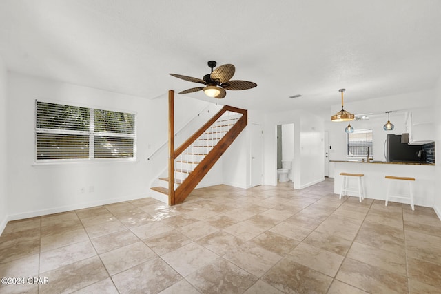 unfurnished living room featuring ceiling fan