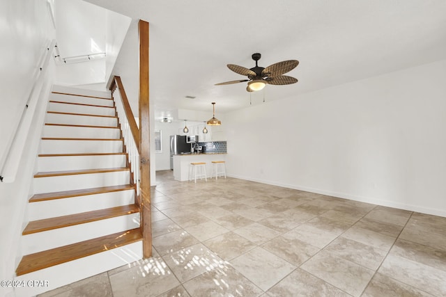 stairs featuring ceiling fan and tile patterned floors