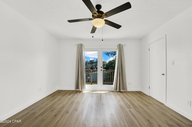 spare room featuring light wood-type flooring, ceiling fan, and french doors