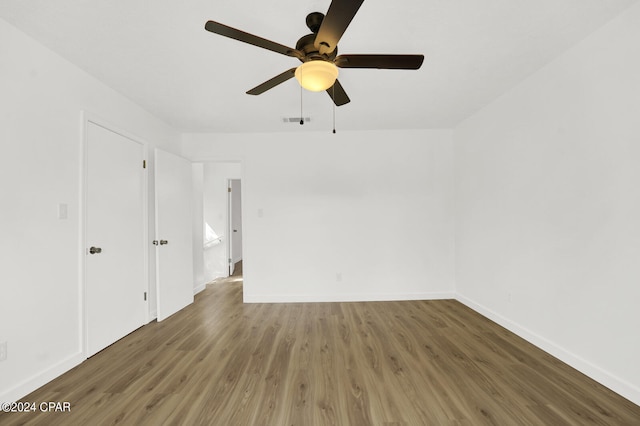 empty room featuring dark wood-type flooring and ceiling fan