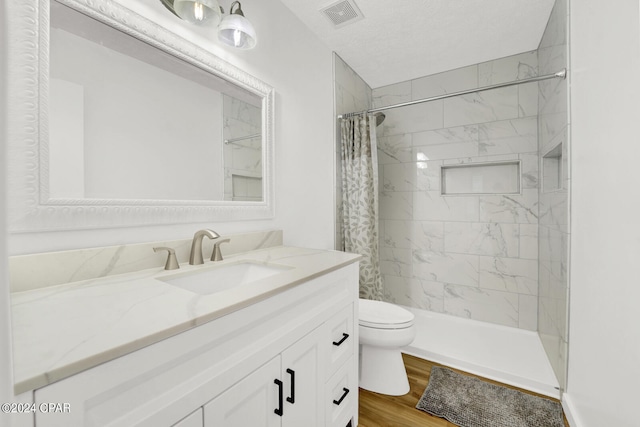 bathroom with toilet, vanity, hardwood / wood-style floors, and a shower with curtain