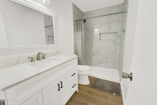 bathroom with a shower with curtain, hardwood / wood-style flooring, vanity, and toilet