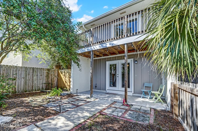 back of house featuring french doors, a balcony, and a patio area